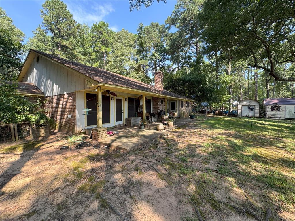 522 Twin Point Drive Benton, LA 71006 - Photo 10 of 33 Rear view of house featuring brick siding, a storage unit, a chimney, a yard, and a shingled roof