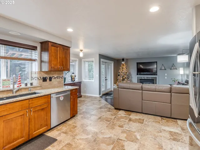 a large white kitchen with stainless steel appliances granite countertop a sink and cabinets