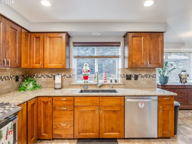 a kitchen with stainless steel appliances granite countertop wooden cabinets a sink and a granite counter tops