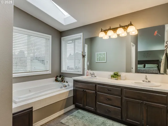a spacious bathroom with double vanity and a mirror