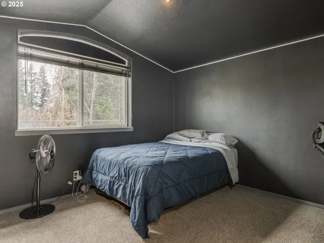 a bed sitting in a bedroom next to a window