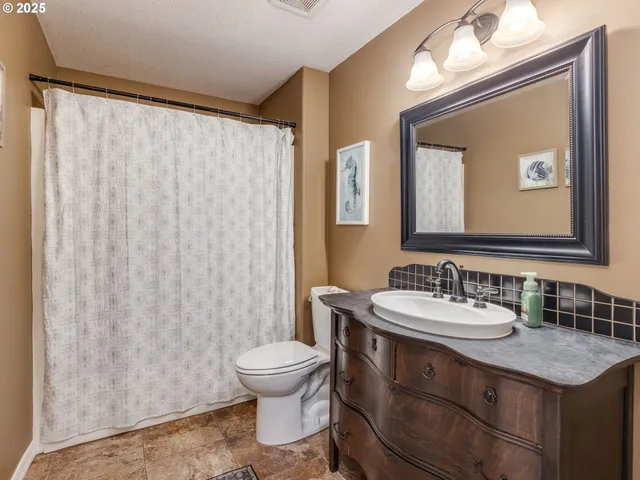 a bathroom with a granite countertop sink and a mirror with toilet