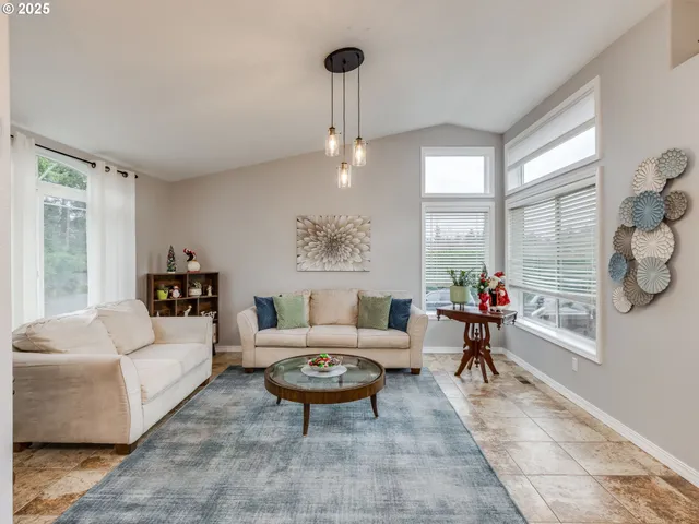 a living room with furniture a table and a large window