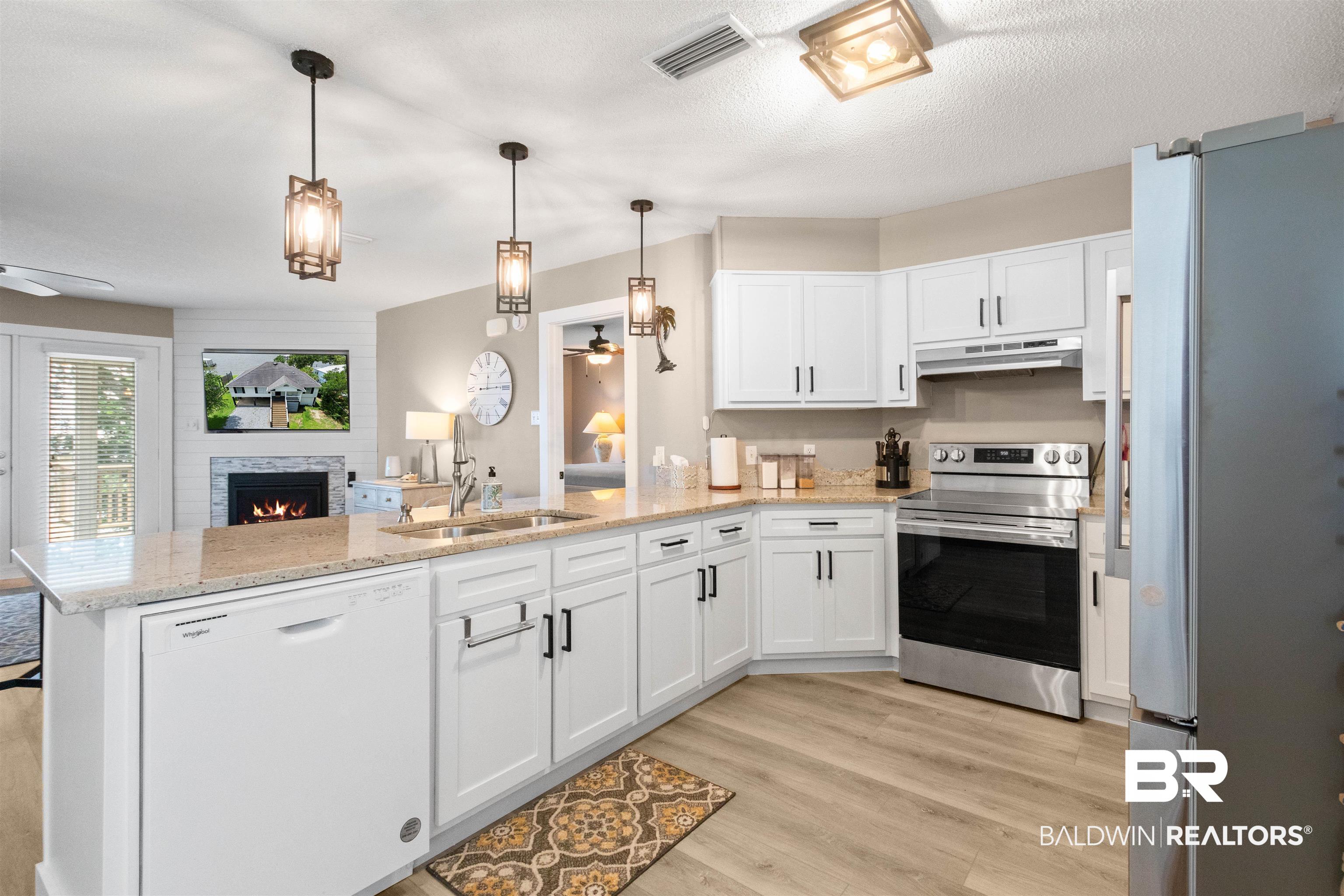 9581 South Bay Street Foley, AL 36535 - Photo 16 of 44 Modern kitchen featuring white cabinetry, light-toned countertops, and a full suite of stainless steel appliances