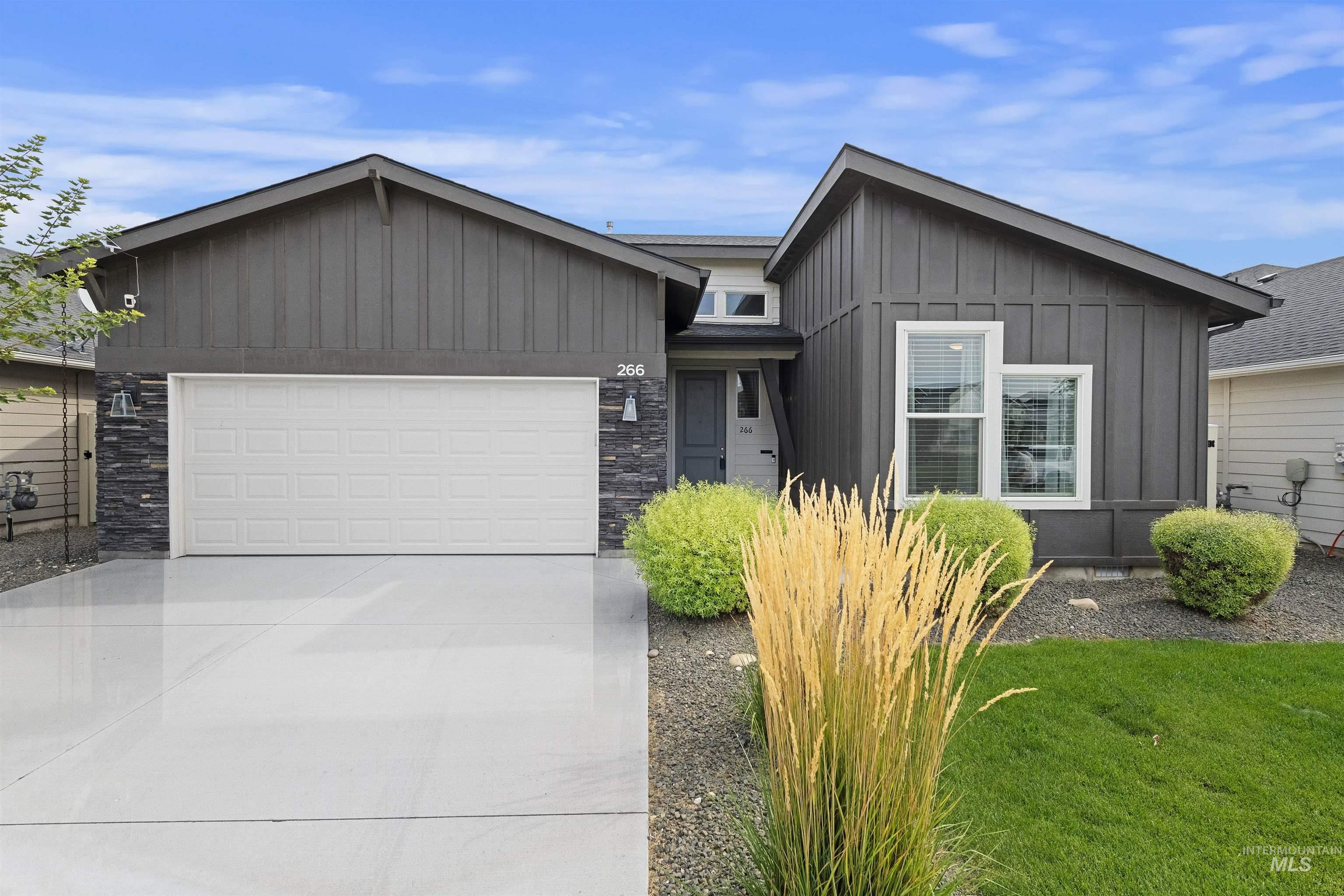 266 South Sunset Point Way Meridian, ID 83642 - Photo 1 of 1 View of front of property featuring board and batten siding, a garage, concrete driveway, and stone siding