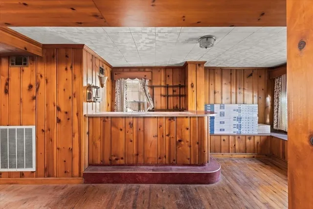 a view of a hallway with wooden floor and furniture