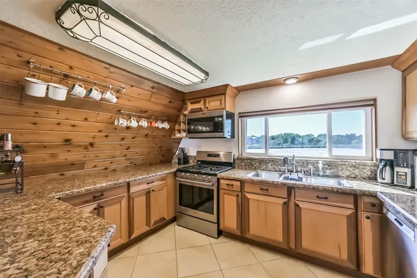 a kitchen with stainless steel appliances granite countertop a stove and cabinets