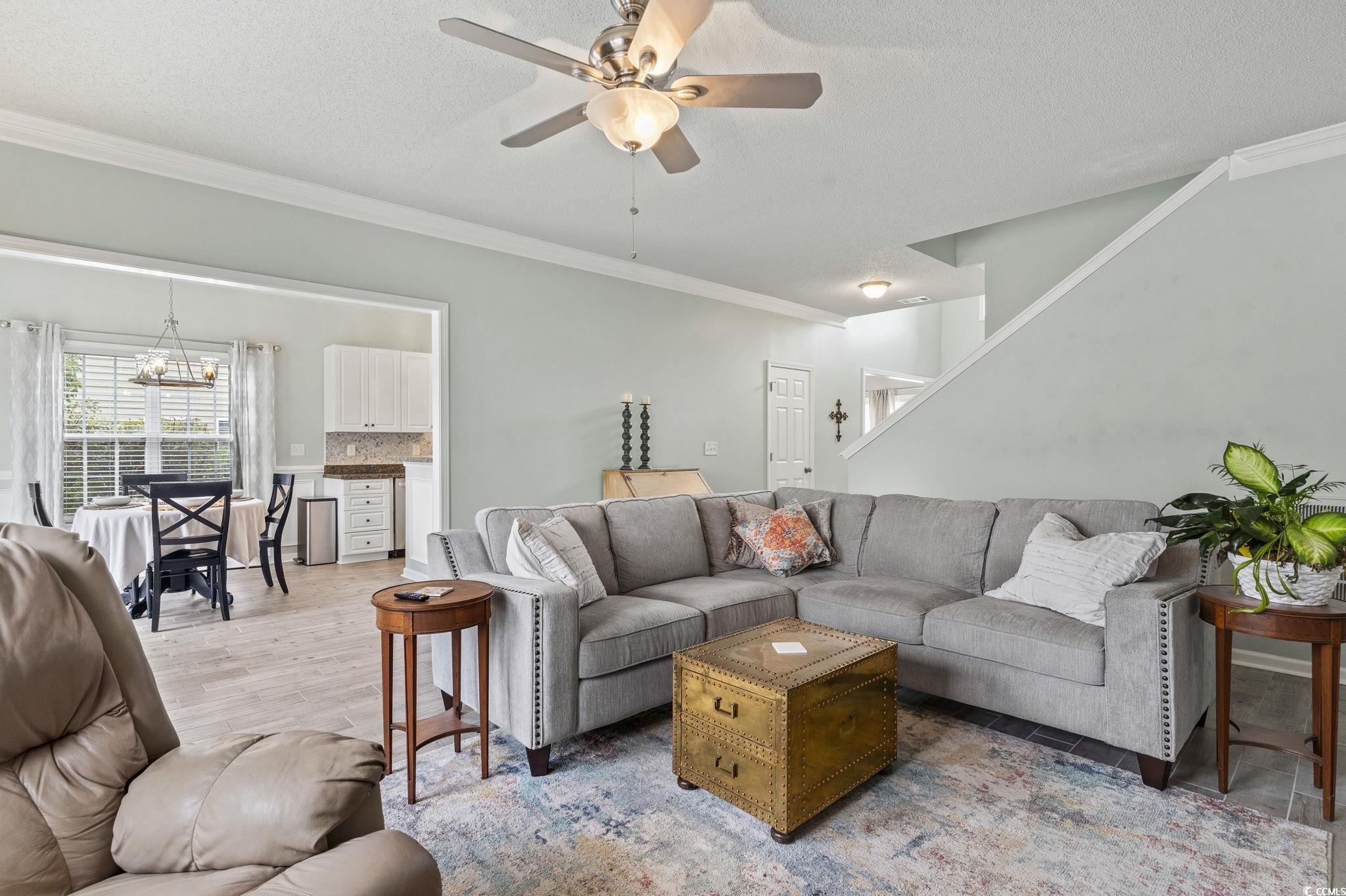 212 Duchess Court Myrtle Beach, SC 29588 - Photo 11 of 40 Living area with ornamental molding, ceiling fan, a textured ceiling, stairway, and wood finished floors