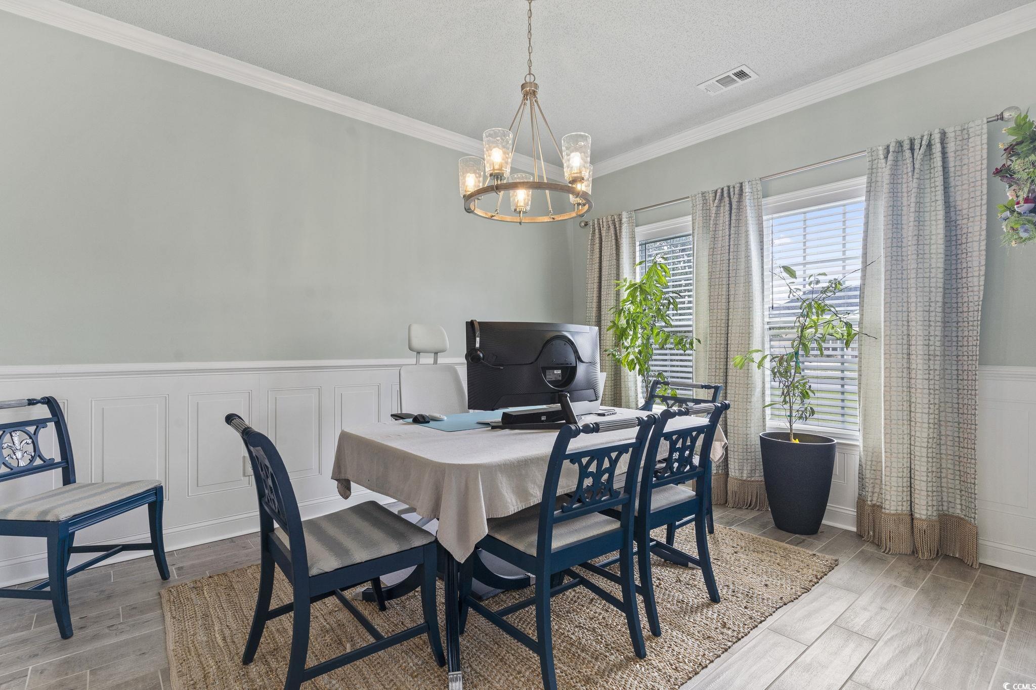 212 Duchess Court Myrtle Beach, SC 29588 - Photo 18 of 40 Dining space with a wainscoted wall, ornamental chair molding, and a chandelier