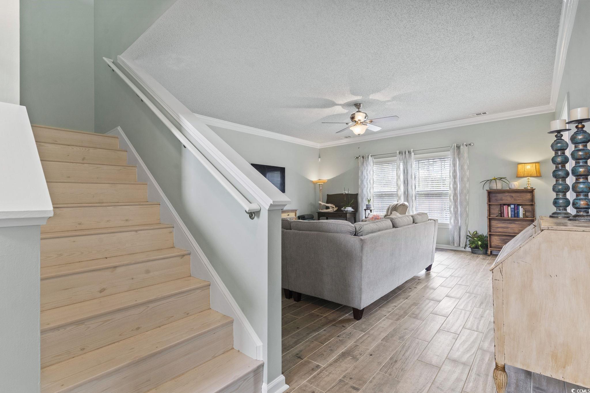 212 Duchess Court Myrtle Beach, SC 29588 - Photo 19 of 40 Living room with wood stairs, crown molding, light and a ceiling fan