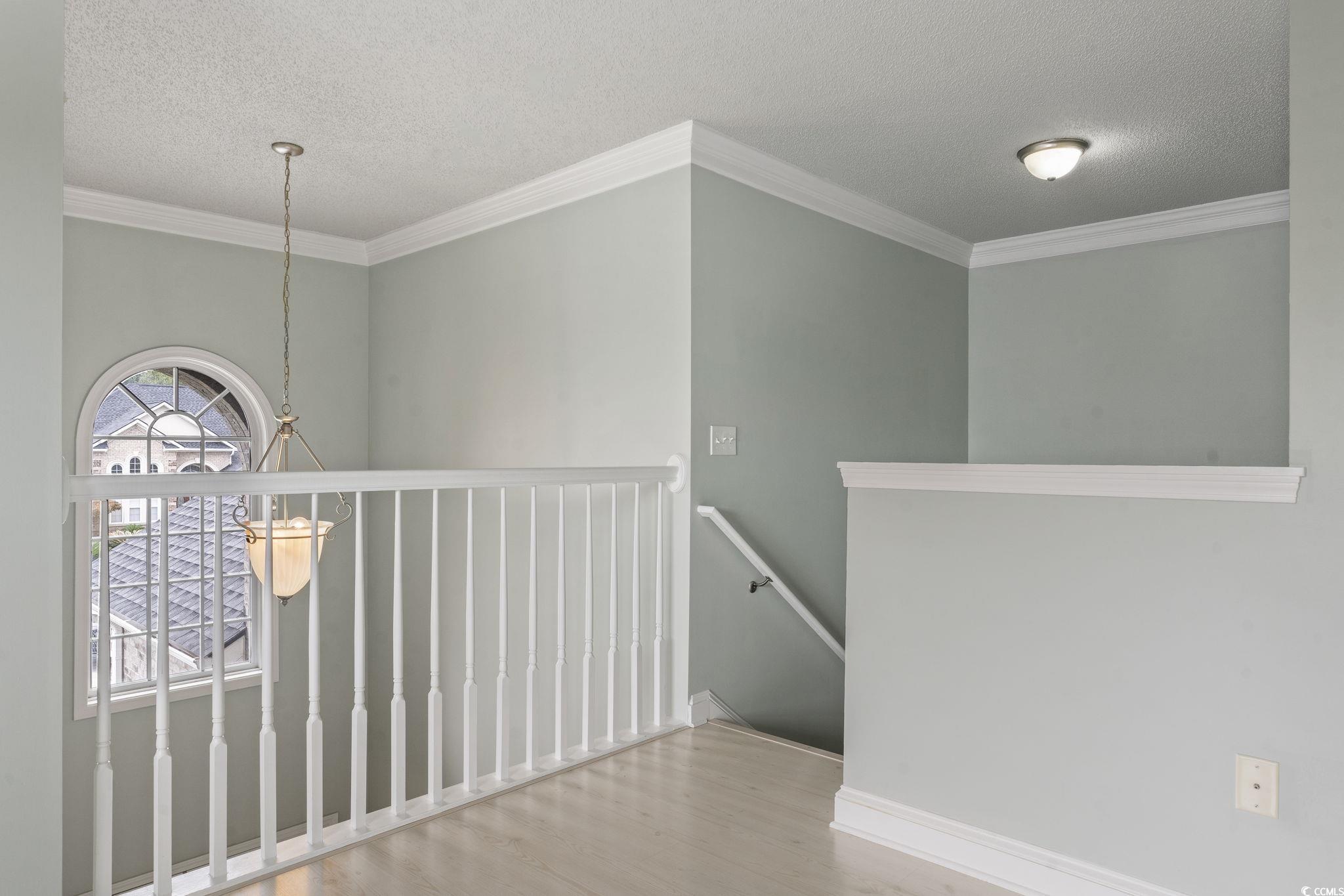 212 Duchess Court Myrtle Beach, SC 29588 - Photo 20 of 40 Corridor with an upstairs landing, crown molding, a , and wood finished floors
