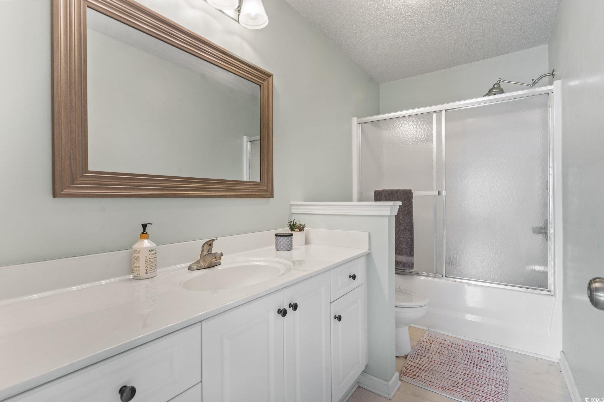 212 Duchess Court Myrtle Beach, SC 29588 - Photo 25 of 40 Full bath featuring vanity, bath / shower combo with glass door and light wood finished floors