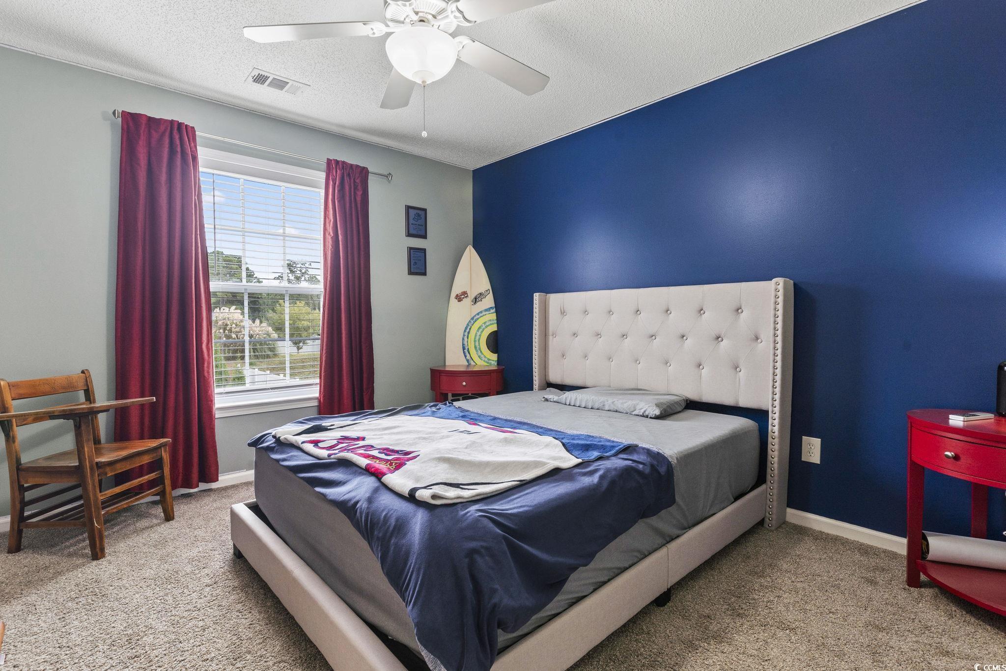 212 Duchess Court Myrtle Beach, SC 29588 - Photo 26 of 40 Bedroom with Walk In closet light carpet, a textured ceiling, and ceiling fan