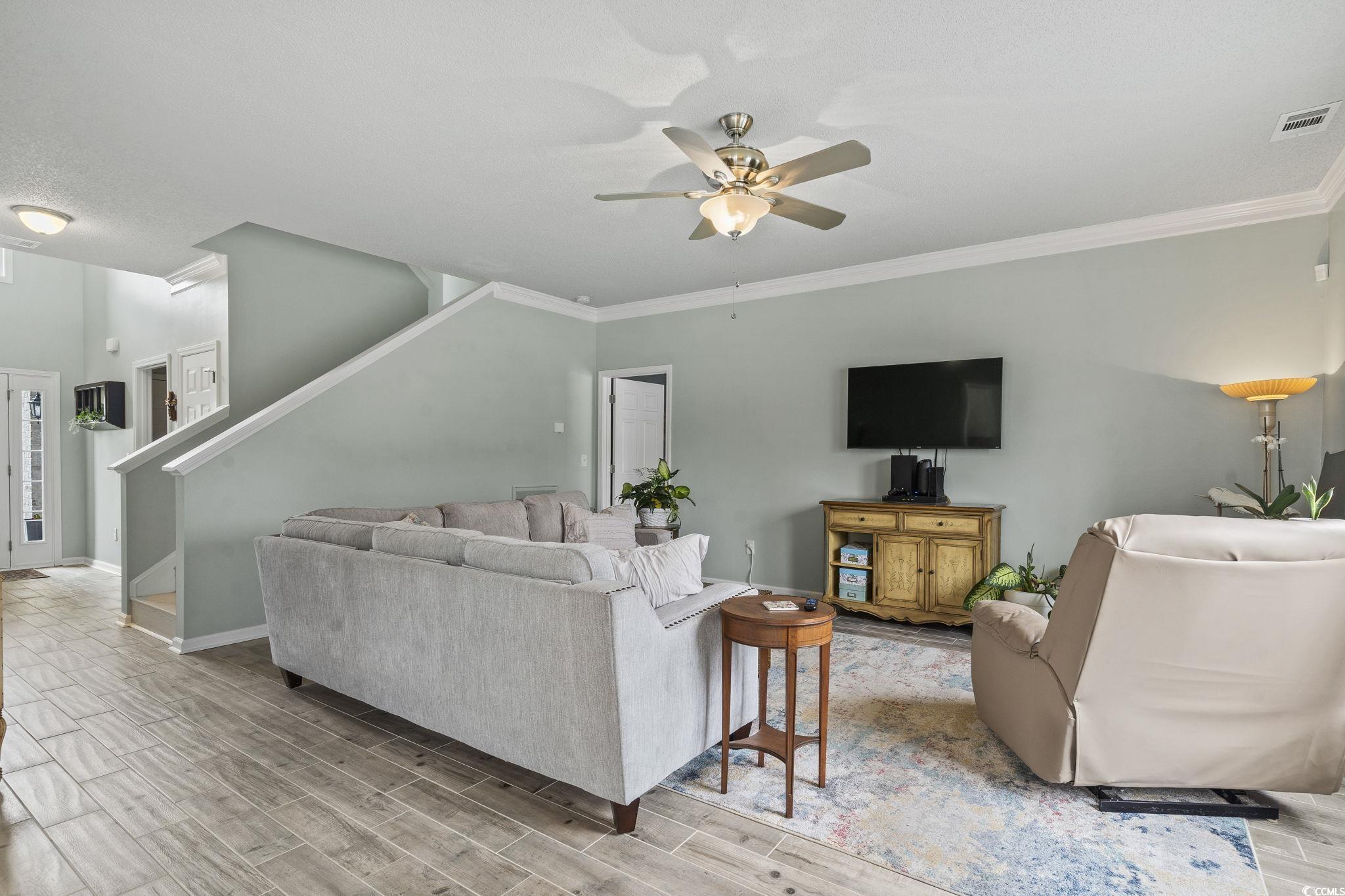 212 Duchess Court Myrtle Beach, SC 29588 - Photo 27 of 40 Living room featuring wood finish floors, stairway, a ceiling fan, and crown molding
