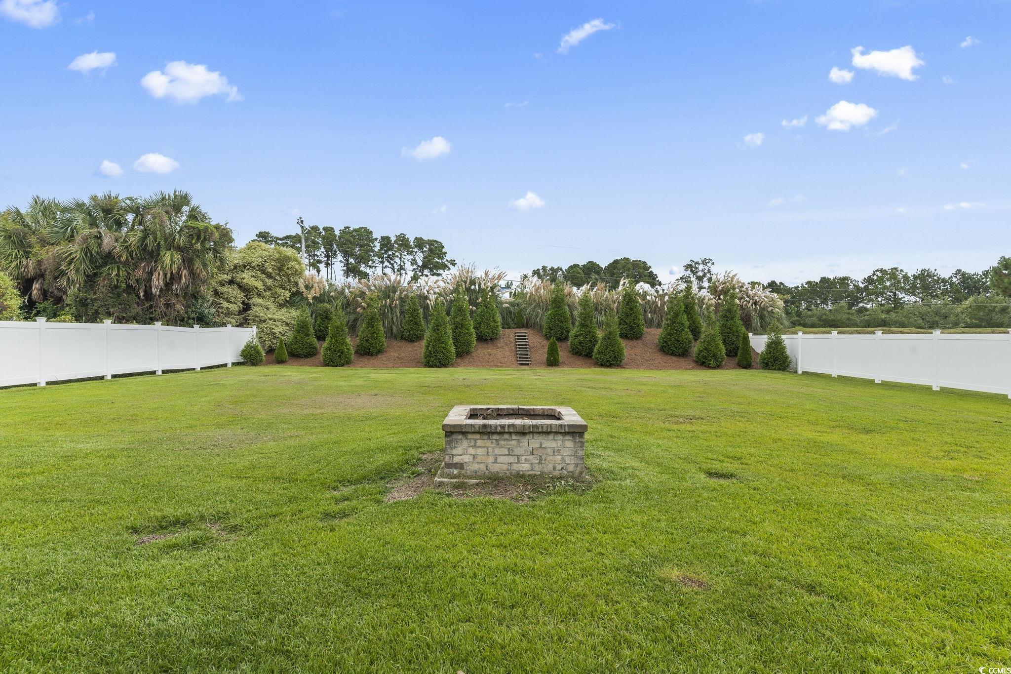 212 Duchess Court Myrtle Beach, SC 29588 - Photo 33 of 40 View of yard featuring a fire pit and view of wooded area