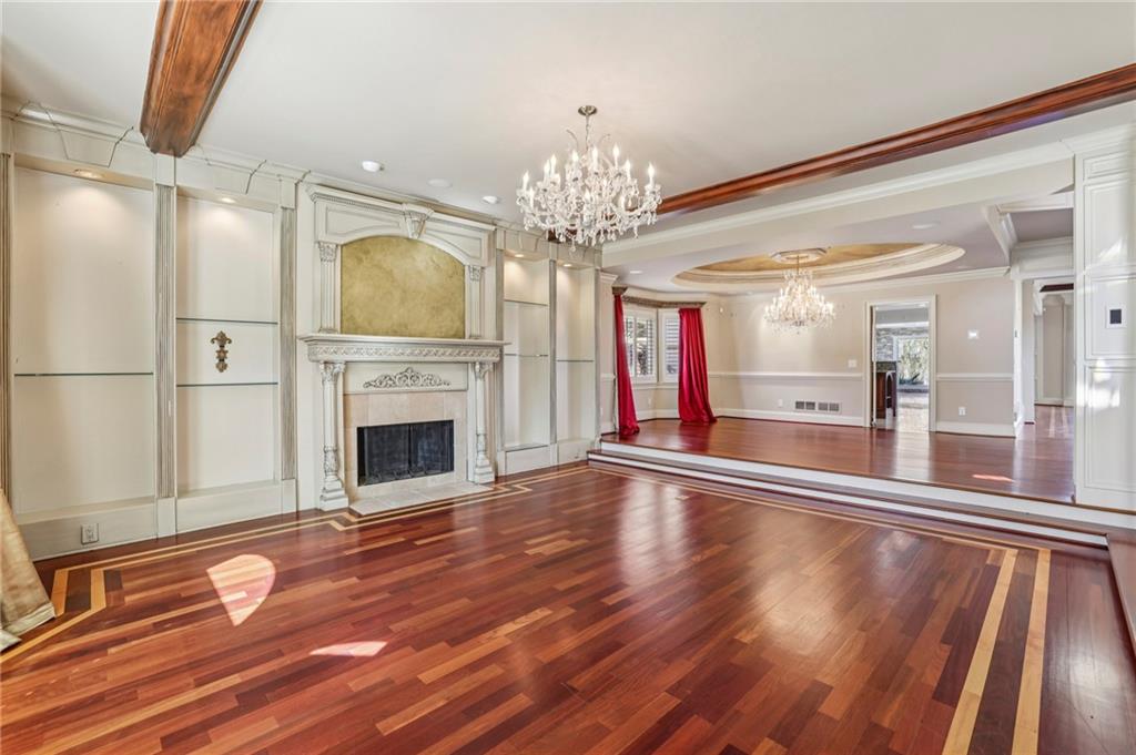 6525 Garrett Road Buford, GA 30518 - Photo 16 of 98 a view of a livingroom with wooden floor a fireplace a chandelier and windows