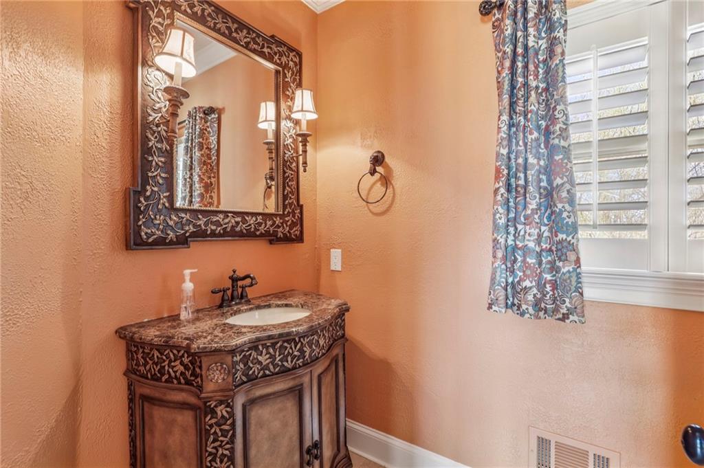 6525 Garrett Road Buford, GA 30518 - Photo 32 of 98 a bathroom with a sink a mirror and a shower