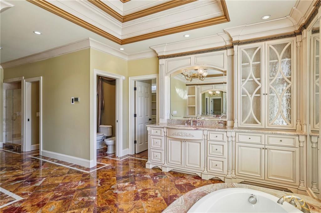 6525 Garrett Road Buford, GA 30518 - Photo 35 of 98 a spacious bathroom with a granite countertop sink and a mirror