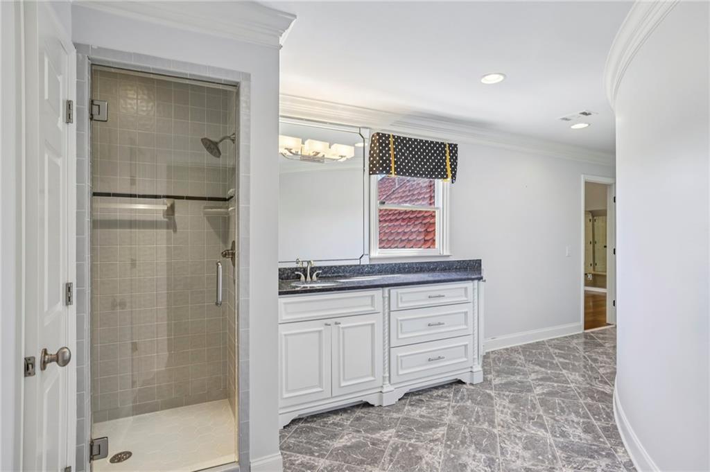 6525 Garrett Road Buford, GA 30518 - Photo 51 of 98 a bathroom with a granite countertop sink a mirror and a shower