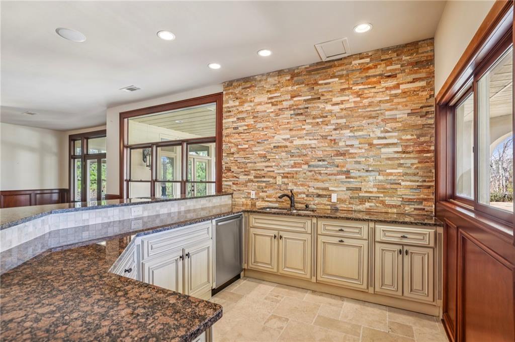6525 Garrett Road Buford, GA 30518 - Photo 59 of 98 a large white kitchen with granite countertop a sink and dishwasher a stove top oven with wooden floor