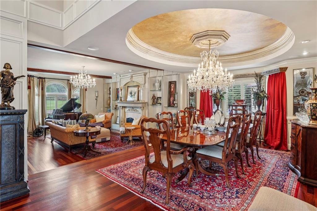 6525 Garrett Road Buford, GA 30518 - Photo 82 of 98 a view of a dining room with furniture a chandelier and wooden floor