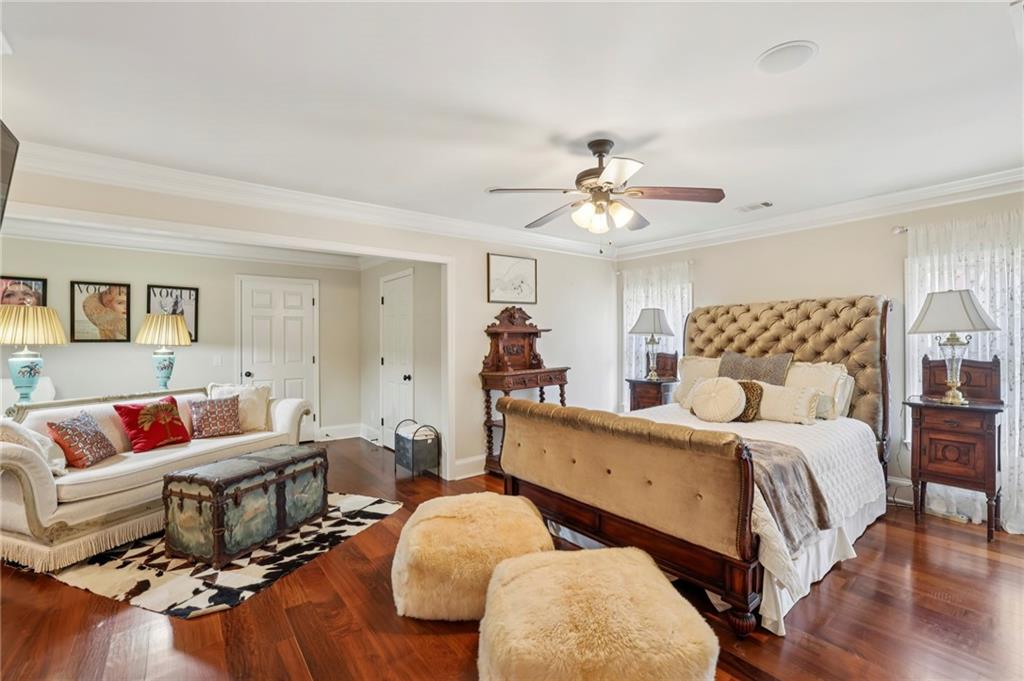 6525 Garrett Road Buford, GA 30518 - Photo 90 of 98 a spacious bedroom with a bed and wooden floor