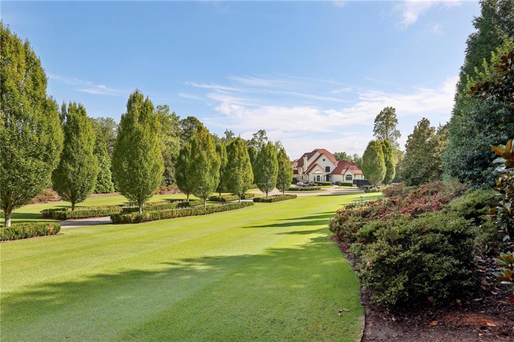 6525 Garrett Road Buford, GA 30518 - Photo 10 of 98 a view of a swimming pool with an ocean and house in the background
