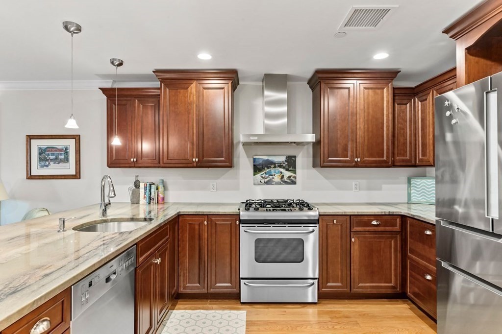 91 Front Street, Unit 104 Scituate, MA 02066 - Photo 12 of 26 a kitchen with a sink stove and cabinets