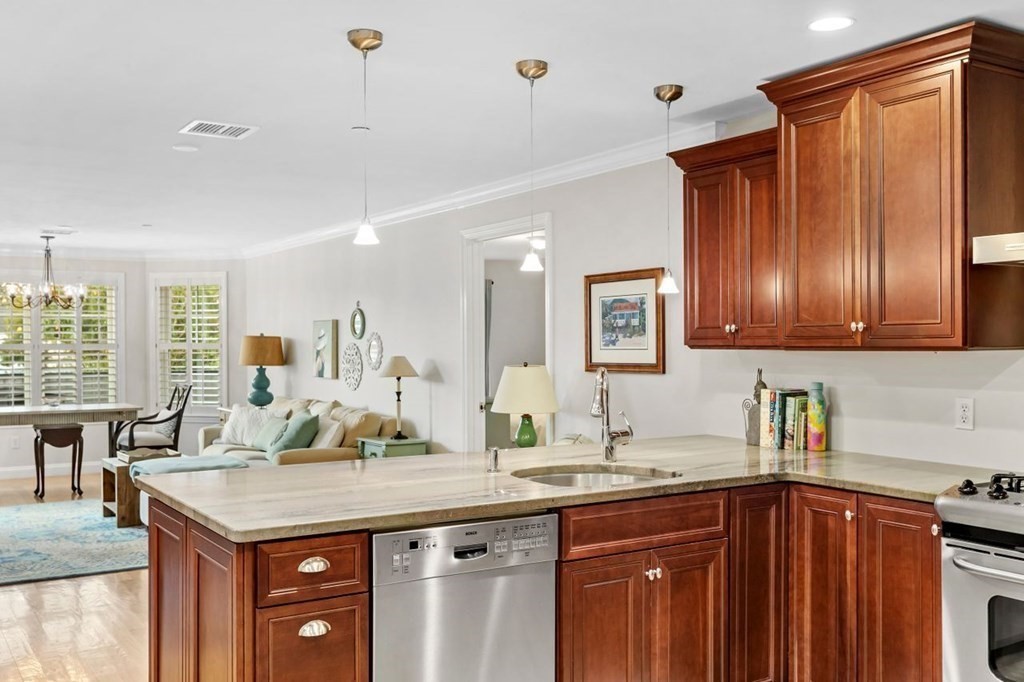 91 Front Street, Unit 104 Scituate, MA 02066 - Photo 13 of 26 a kitchen with stainless steel appliances granite countertop a sink and wooden cabinets