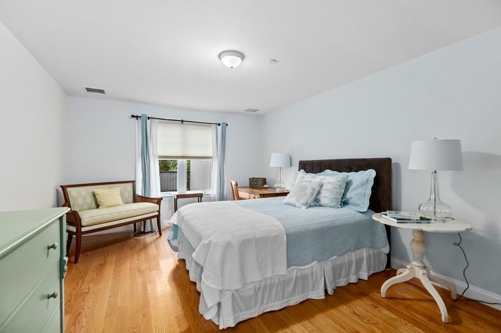 91 Front Street, Unit 104 Scituate, MA 02066 - Photo 16 of 26 a bedroom with a bed and a night stand