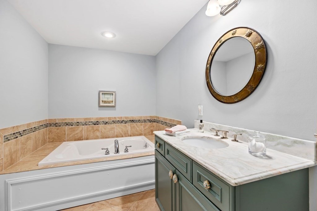 91 Front Street, Unit 104 Scituate, MA 02066 - Photo 19 of 26 a bathroom with a granite countertop sink and a mirror