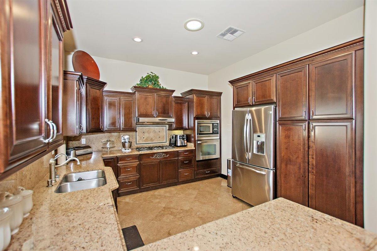 82553 Doolittle Drive Indio, CA 92201 - Photo 11 of 47 a kitchen with stainless steel appliances granite countertop a refrigerator and a sink