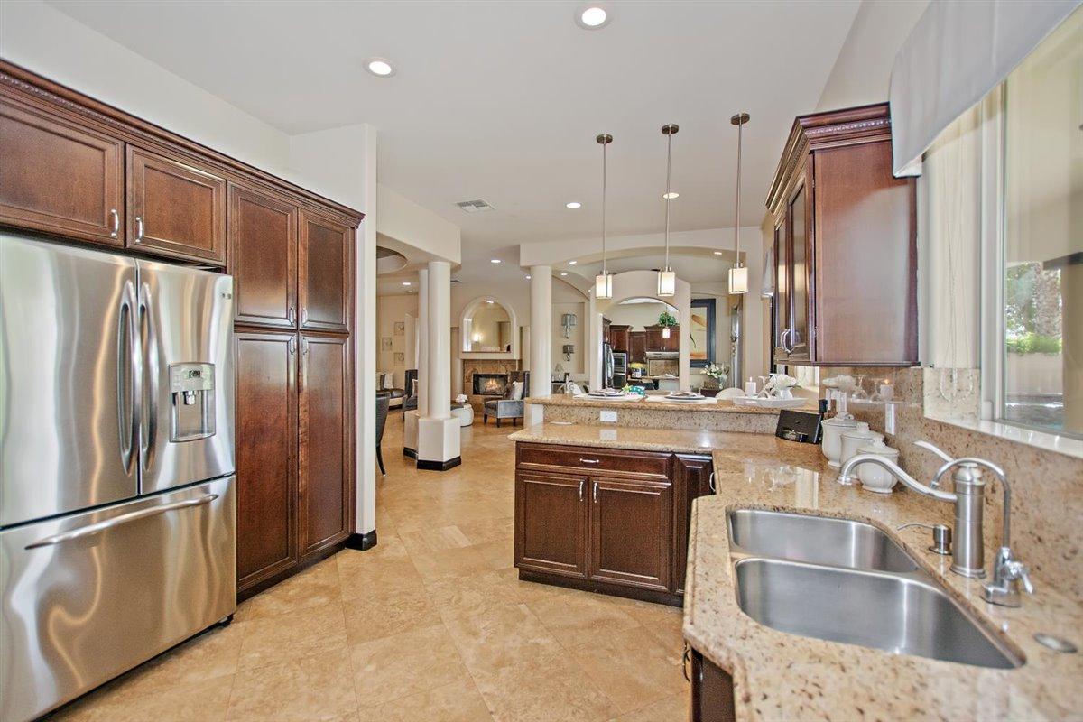 82553 Doolittle Drive Indio, CA 92201 - Photo 14 of 47 a kitchen with stainless steel appliances granite countertop a refrigerator a sink a stove and a sink with wooden floor