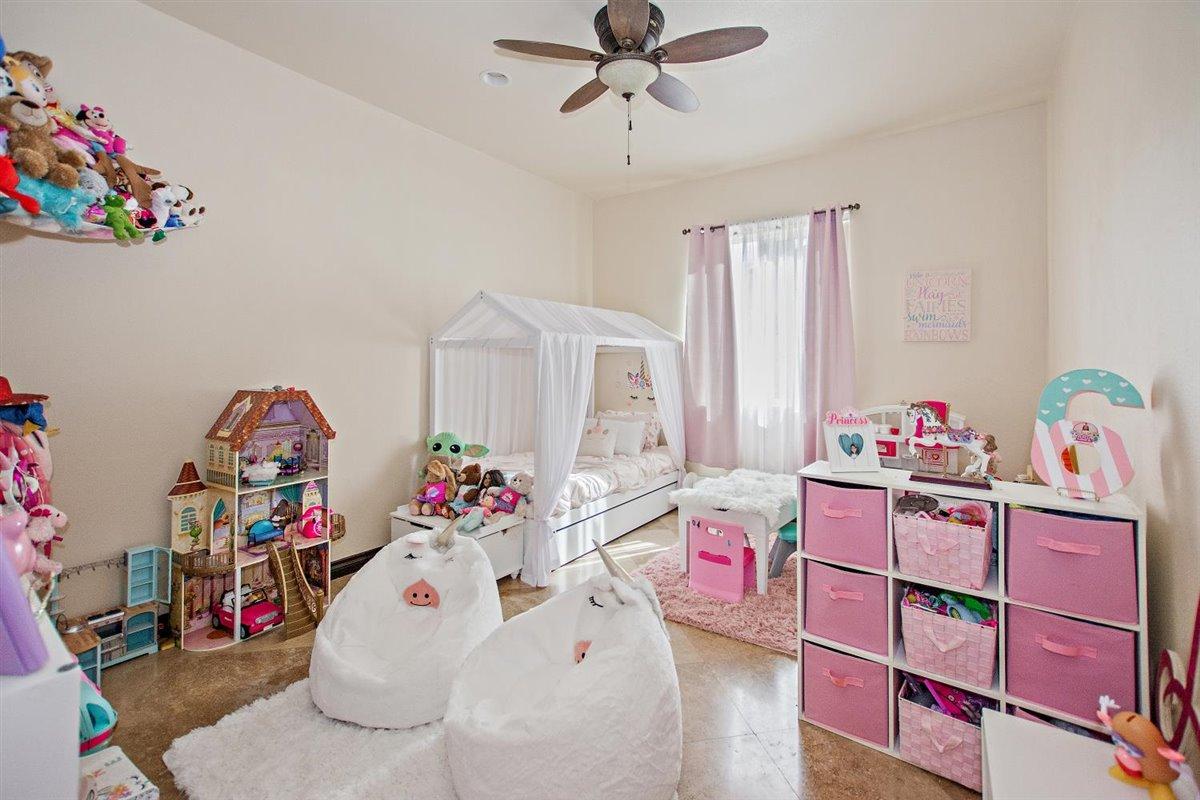 82553 Doolittle Drive Indio, CA 92201 - Photo 28 of 47 a bedroom with a bed dresser and a chandelier