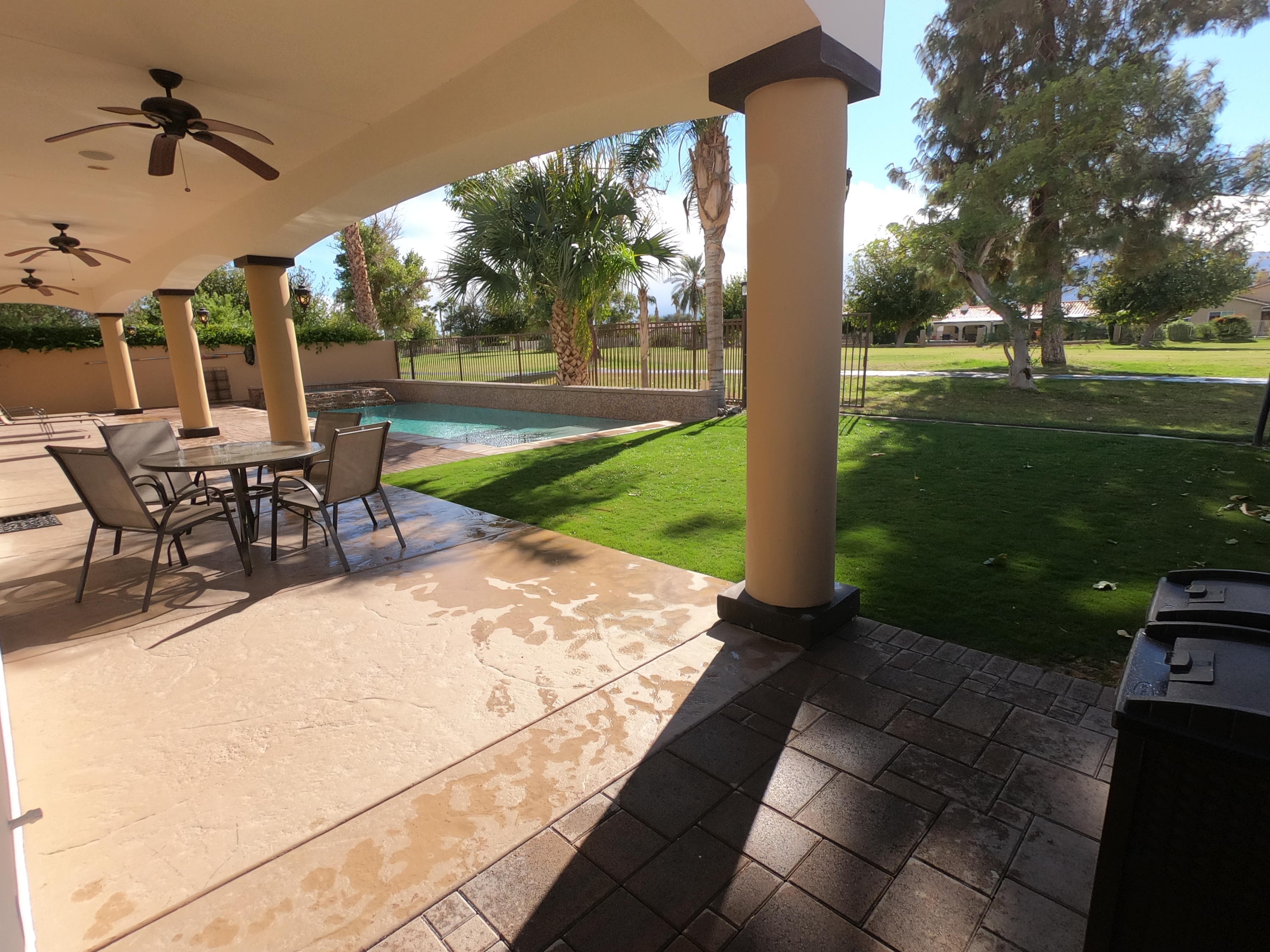 82553 Doolittle Drive Indio, CA 92201 - Photo 36 of 47 a view of a patio with a table chairs and a backyard