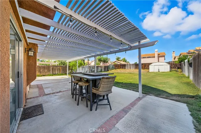 a view of a patio with table and chairs under an umbrella