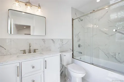 a bathroom with a sink a toilet and a mirror