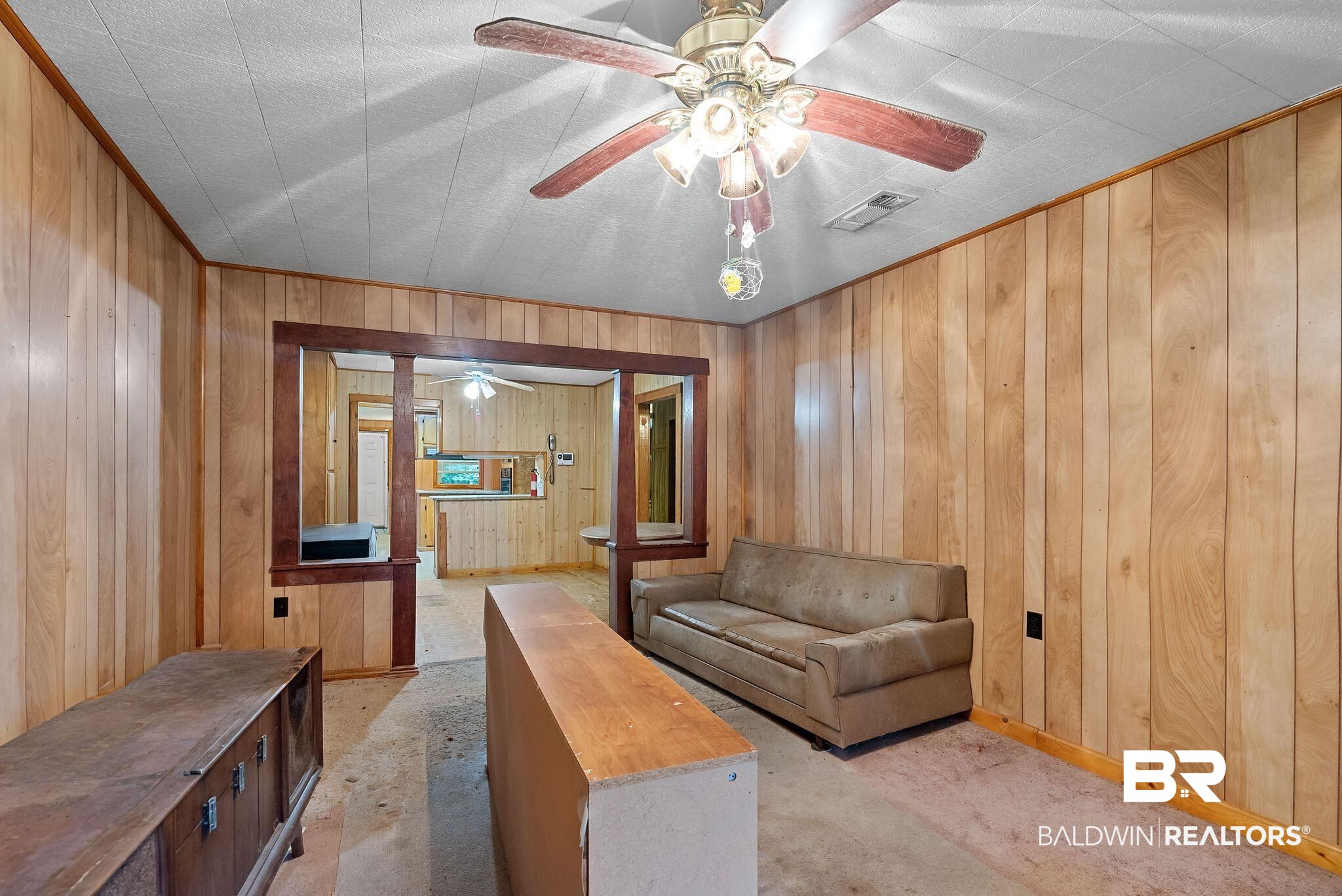 18318 Kendrick Road Robertsdale, AL 36567 - Photo 15 of 39 Living area featuring wood paneling throughout, a ceiling fan with integrated lighting, and a framed doorway