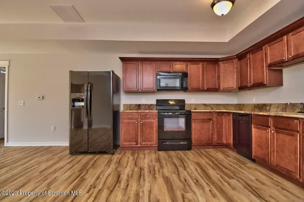 a kitchen with a refrigerator sink and wooden cabinets