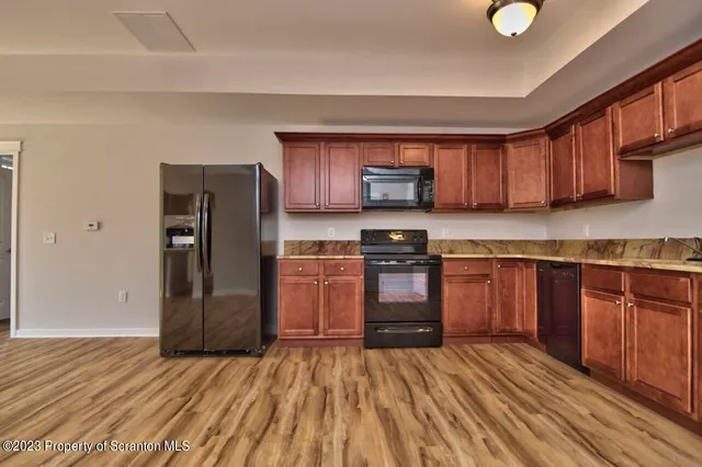 a kitchen with a refrigerator sink and wooden cabinets
