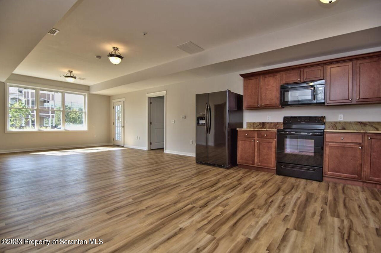 135 Bianca Way Old Forge, PA 18518 - Photo 5 of 11 a kitchen with stainless steel appliances granite countertop a refrigerator a stove top oven a sink and dishwasher with wooden floor