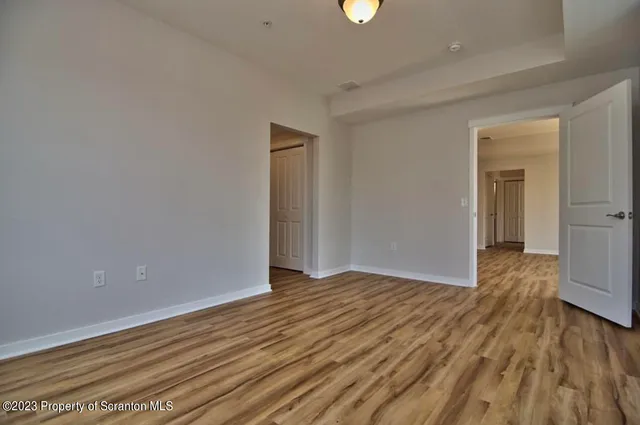a view of an empty room with wooden floor