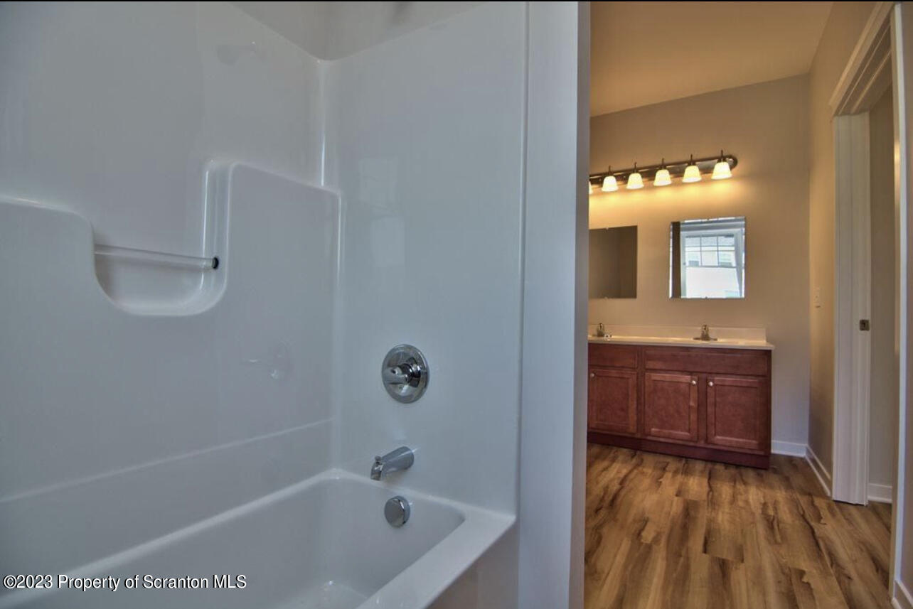 135 Bianca Way Old Forge, PA 18518 - Photo 8 of 11 a bathroom with a sink a mirror and a bathtub