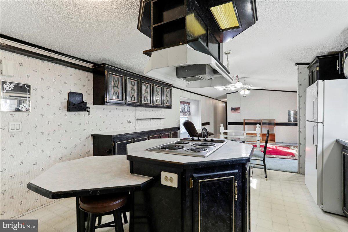 111 North Fairfax Boulevard Ranson, WV 25438 - Photo 13 of 32 a kitchen with stainless steel appliances kitchen island granite countertop a table chairs and a refrigerator