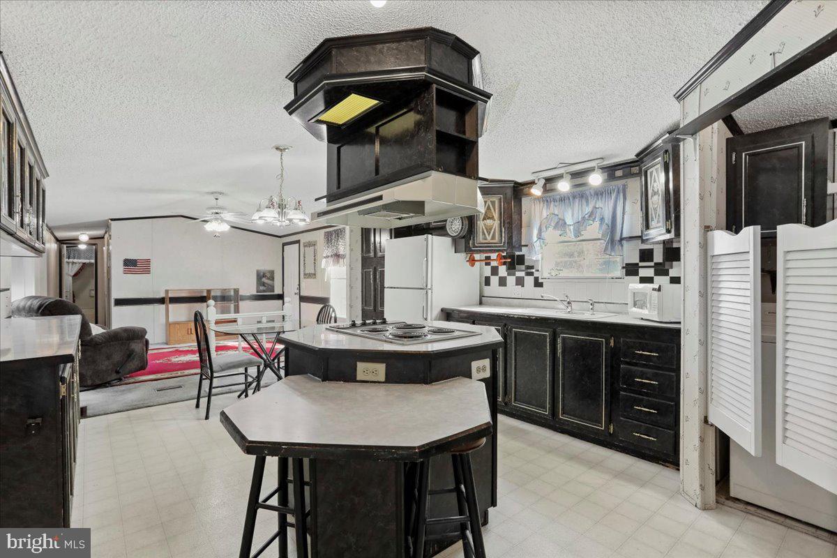 111 North Fairfax Boulevard Ranson, WV 25438 - Photo 14 of 32 a kitchen with stainless steel appliances kitchen island granite countertop a table chairs sink and cabinets