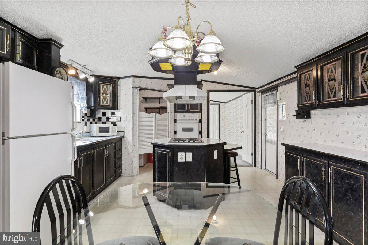 111 North Fairfax Boulevard Ranson, WV 25438 - Photo 8 of 32 a kitchen with stainless steel appliances granite countertop a stove refrigerator a dining table and chairs with wooden floor