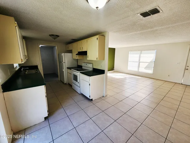 a kitchen with a sink a stove and cabinets