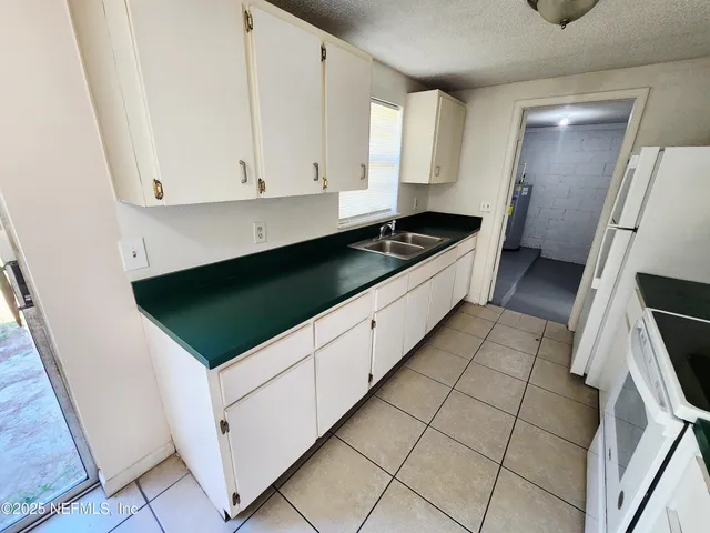 a kitchen with granite countertop white cabinets and white appliances