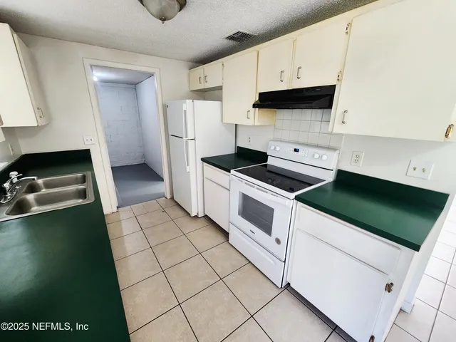 a kitchen with cabinets and white appliances