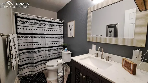 a bathroom with a sink a toilet and mirror
